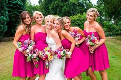 a group of women standing next to each other on top of a lush green field