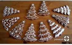 decorated cookies arranged in the shape of christmas trees and snowflakes on a wooden table