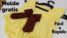 a yellow shirt with a brown bow on it and some black hangers next to it