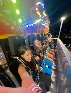 two girls are riding on a roller coaster