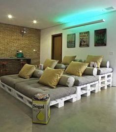 a room with couches made out of pallets and some yellow pillows on them