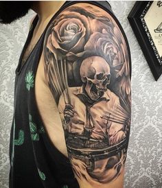 a man with a skull and roses tattoo on his arm is holding a knife in front of him