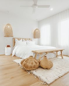 a bedroom with white walls and wooden floors