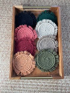 four different colors of hair scrunffs in a wooden box on the carpeted floor