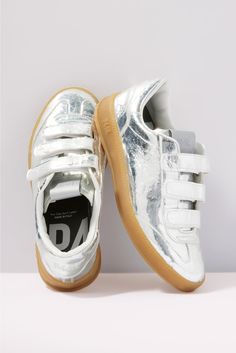 Add some shine to your look with these silver metallic sneakers by P448, featuring a low-top silhouette with a velcro closure, amber tread, and comfy memory foam insole. Each pair of P448 sneakers is crafted to maximize comfort, while the unexpected color combinations, textures, and patterns add a unique flair. All P448 sneakers are designed and made in Italy. | P448 Women's Monza Velcro Sneakers, Size 40, Silver Modern Metallic Sneakers With Rubber Sole, Modern Metallic Silver Sneakers With Round Toe, Modern Metallic Silver Round Toe Sneakers, Silver Sneakers With Removable Insole, Silver Sneakers With Removable Insole And Round Toe, P448 Sneakers, Unexpected Color Combinations, Textures And Patterns, Fall Closet