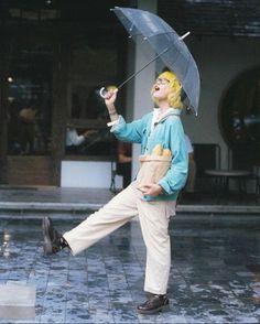 a man with an umbrella and some food in his hand