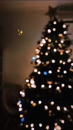 a small christmas tree is lit up in the dark with white and blue lights on it