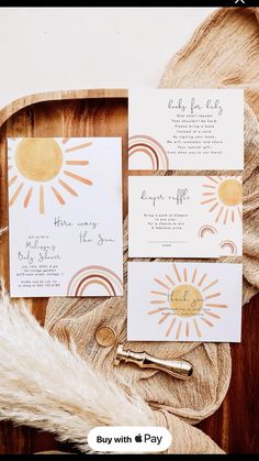 the wedding stationery is laid out on a wooden tray