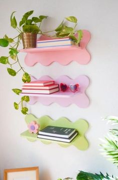 three shelves with books and plants on them