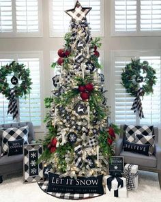 a christmas tree decorated with black and white ribbons, plaid bows, wreaths and other holiday decorations