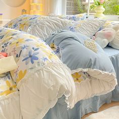 a bed with blue and yellow comforters on it