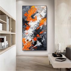 an abstract painting hangs in the corner of a room