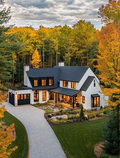 a large white house surrounded by trees in the fall