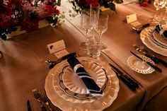 the table is set with silverware and place settings