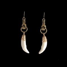 Real, bright white, 1 inch coyote canine teeth hang from 1 inch gold plated, Victorian style hands. Each are on gold filled French hook earrings. They drop to almost 3 inches. The coyote teeth are professionally cleaned and sterile. As with all of our natural animal products, these are harvested humanely from animals that are already deceased. None of our natural components are from animals that have been killed for the purpose of use in our jewelry, they are all by-products. This piece of jewelry is sent in a bubble pack envelope via US postal service, first class mail with insurance and comes in a gift box. International rate is $23. Buyers are responsible for any customs and import taxes that may apply. I am sorry, but Necromance is not responsible for delays due to customs, since when Animal Bone Jewelry Wire, Fang Earring, Coyote Jewelry, Fang Jewelry, Canine Teeth, Tooth Earrings, Taxidermy Jewelry, Canine Tooth, Animal Teeth