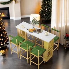 a dining room table with green chairs next to a christmas tree