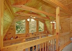 the inside of a cabin with wooden walls and stairs leading up to an upper level bathroom