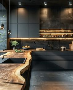 a kitchen with black cabinets and wooden counter tops, along with an island in the middle