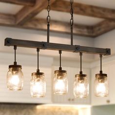 mason jar chandelier with lights hanging from it's sides in a kitchen