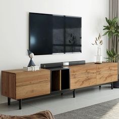 a flat screen tv mounted to the side of a wooden entertainment center