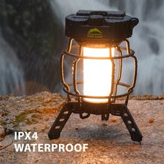 a light that is sitting on top of a rock with water falling in the background