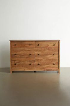 a large wooden dresser sitting on top of a metal floor next to a white wall