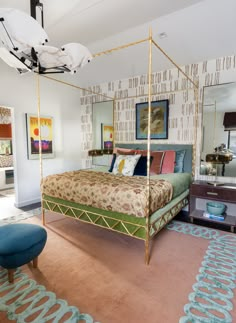 a bedroom with a four poster bed and blue ottoman