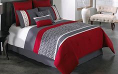 a bed with red and grey comforters in a room