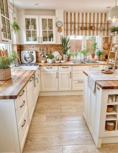 a kitchen filled with lots of white cabinets and wooden counter tops next to a stove top oven