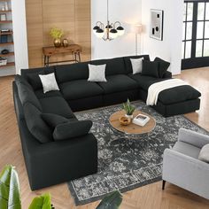 a living room filled with black couches and chairs next to a rug on top of a hard wood floor