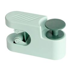 a white plastic object with two knobs on the front and one button on the back