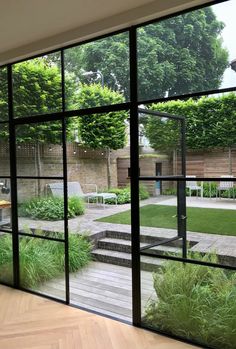 an open patio with wooden flooring and large glass doors leading to the back yard