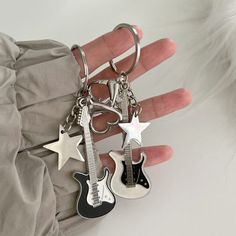 a person is holding two guitar key chains in their hand, one with a star on it