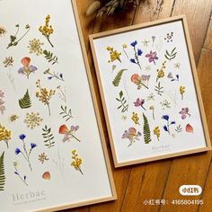 two cards with pressed flowers on them sitting on a table next to a vase filled with wildflowers