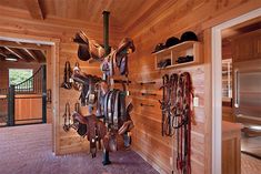 there are many horse saddles hanging on the wall