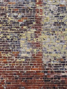 an old brick wall with peeling paint on it