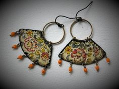 two pairs of earrings with orange beads hanging from them