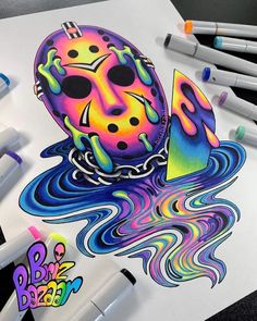 a drawing of a colorful mask on top of a sheet of paper next to markers