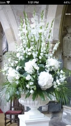 a large white vase filled with flowers on top of a table