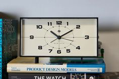 a clock sitting on top of a stack of books