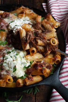 a skillet filled with pasta, meat and cheese