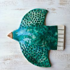 a ceramic bird with holes on it's body