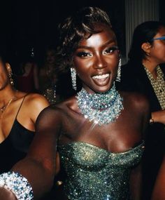 a woman in a green dress is posing for the camera with other women around her