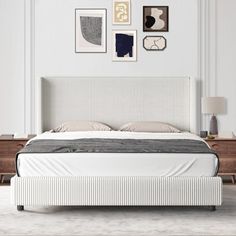 a white bed sitting in the middle of a bedroom