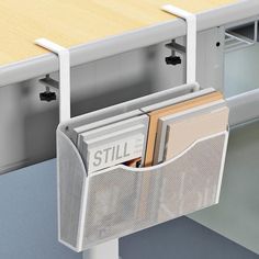 a magazine rack with magazines in it is attached to the side of a desk,