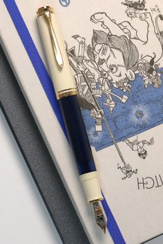 a pen sitting on top of a notebook next to a blue and white book cover