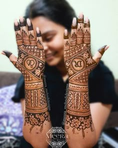 a woman holding her hands up to show the hendi