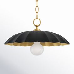 a black and gold pendant light hanging from a chain