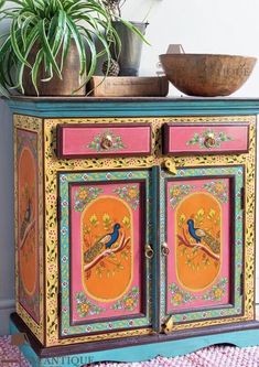 an ornate painted cabinet with two birds on it