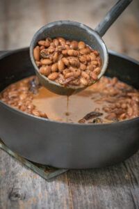 a pan filled with beans on top of a wooden table